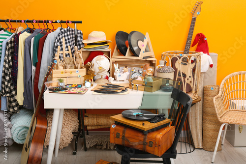 Fotografía Many different stuff near orange wall indoors. Garage sale
