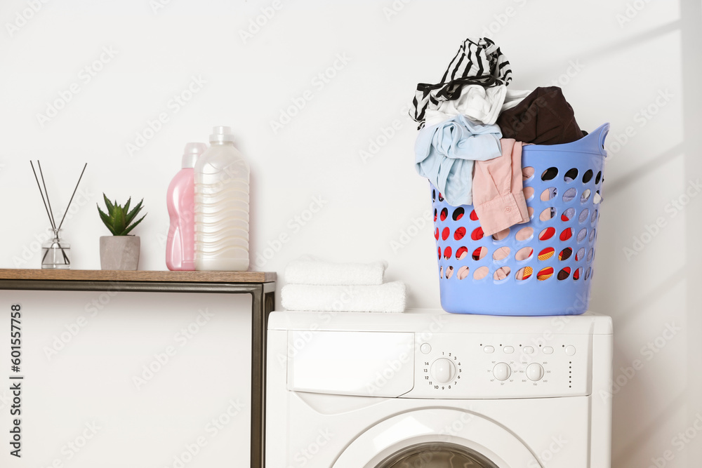 Laundry basket overfilled with clothes on washing machine in bathroom Laundry basket overfilled with clothes on washing machine in bathroom