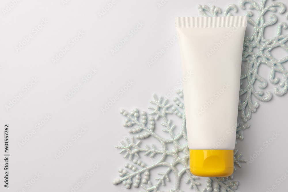 Winter skin care. Hand cream and decorative snowflakes on white background, top view. Space for text Winter skin care. Hand cream and decorative snowflakes on white background, top view. Space for text