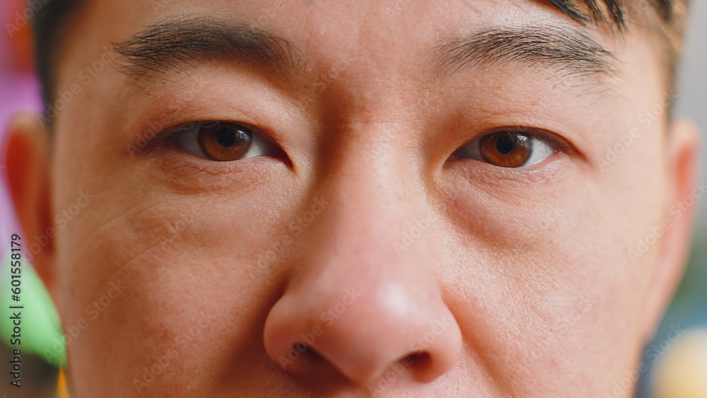Extreme close-up macro portrait of smiling asian man face. Middle-aged guy eyes looking at camera. Adult positive chinese man opening wide his closed eyes. Brown eyes of brunette male attractive model Extreme close-up macro portrait of smiling asian man face. Middle-aged guy eyes looking at camera. Adult positive chinese man opening wide his closed eyes. Brown eyes of brunette male attractive model