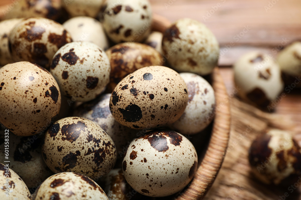 Wooden bowl with quail eggs on table, closeup Wooden bowl with quail eggs on table, closeup