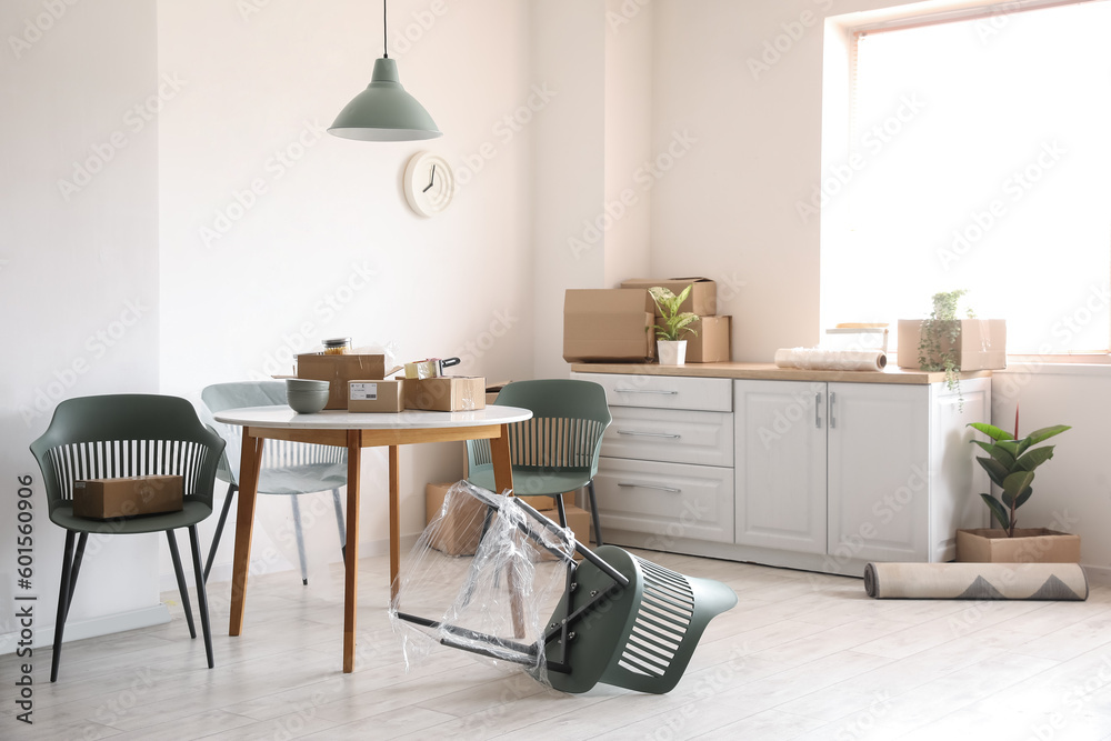 Obraz premium Dining table with cardboard boxes in kitchen on moving day