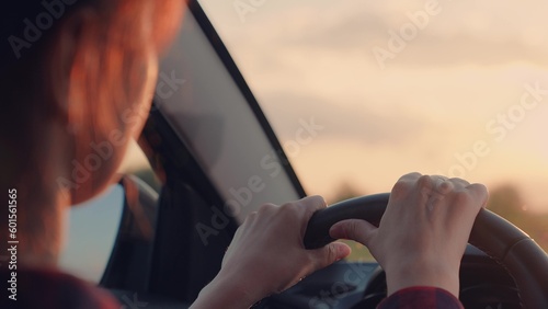 female hand steering wheel car. business trip work. female trip travel adventure. female driver turns the steering wheel of an SUV car van. safe driving car. happy driver sunset.