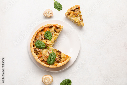 Mushroom pie with spinach leaves and champignons on white grunge table