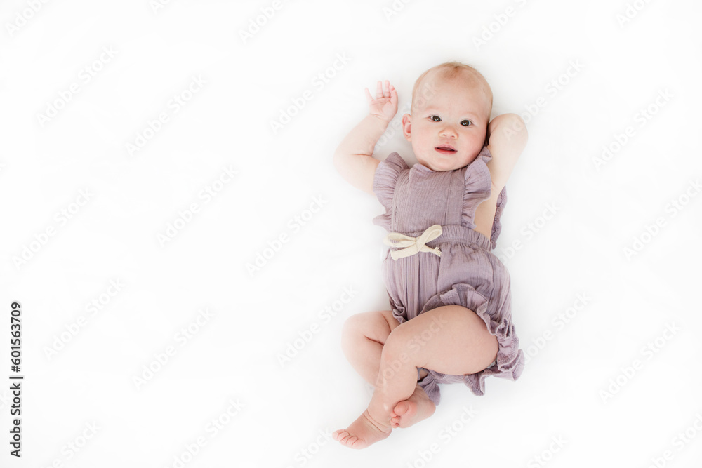 Caucasian baby on the white background. 9-month-old baby girl in a romper. Caucasian baby on the white background. 9-month-old baby girl in a romper.