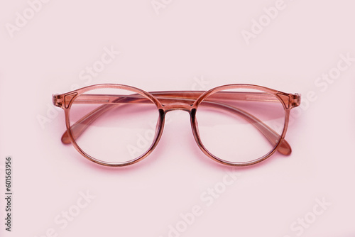 Stylish eyeglasses on pale pink background