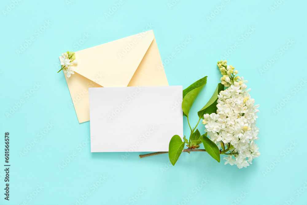 Envelope and blank card with lilac flowers on pale blue background Envelope and blank card with lilac flowers on pale blue background