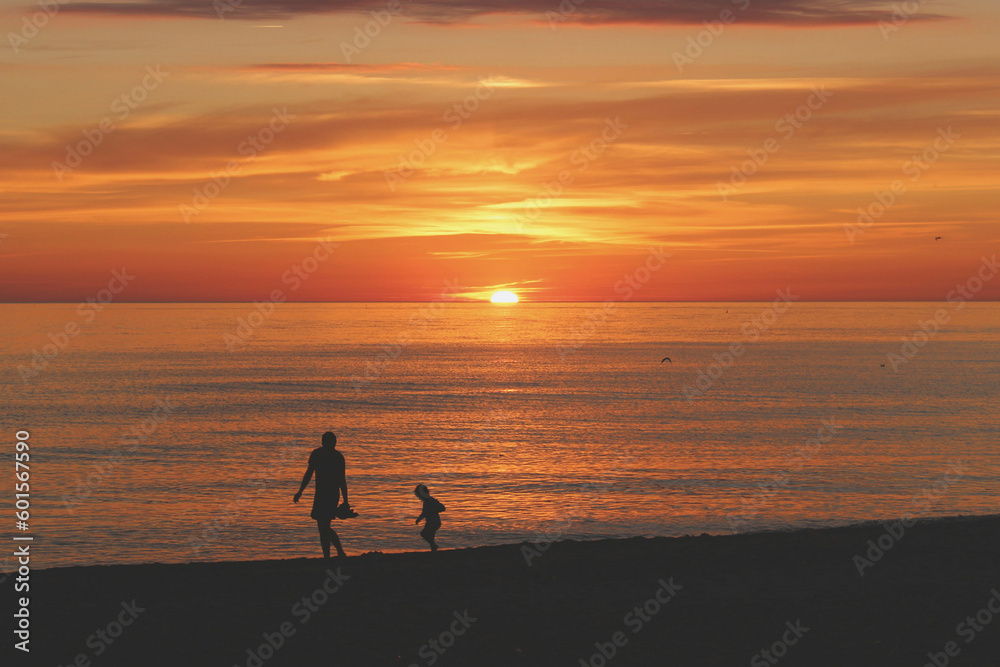 Mother and son running laughing through the brightest sunset on Mother's Day - obrazy, fototapety, plakaty 