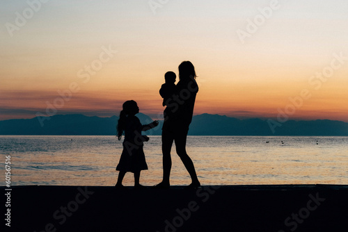 Mother with her girls enjoying the sunset on a beautiful beach on Mother's Day