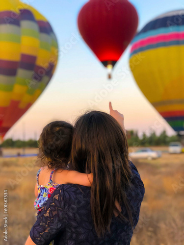Photographie Mother and her baby looking at a beautiful view full of balloons on Mother's Day
