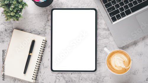 White office desk workplace with blank screen tablet, laptop, notebook, pen and cup of coffee, Top view flat lay.
