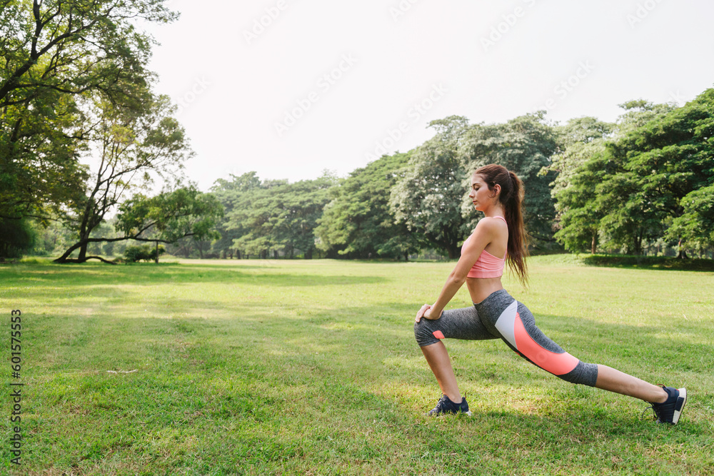 sports woman working out and stretching warm up leg muscle before outdoor running exercise in city park. outdoor fitness. sports woman working out and stretching warm up leg muscle before outdoor running exercise in city park. outdoor fitness.