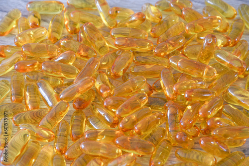 Omega 3 pills scattered on a wooden table