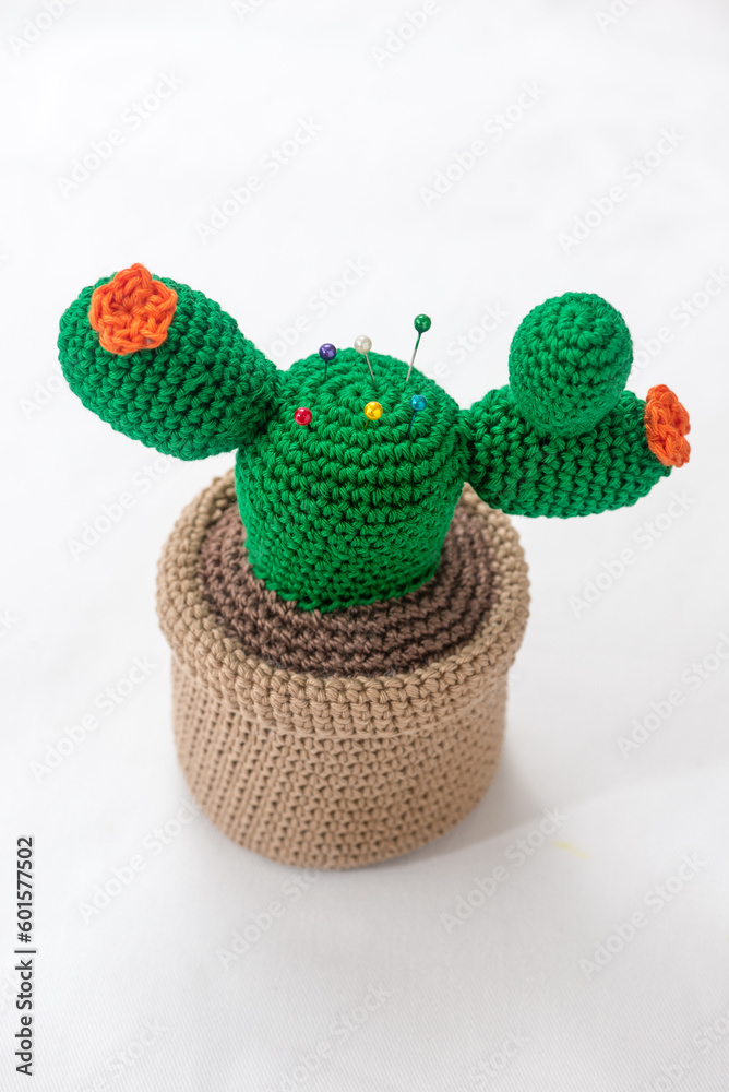 pincushion in the shape of a cactus in a pot, crocheted, on a white background