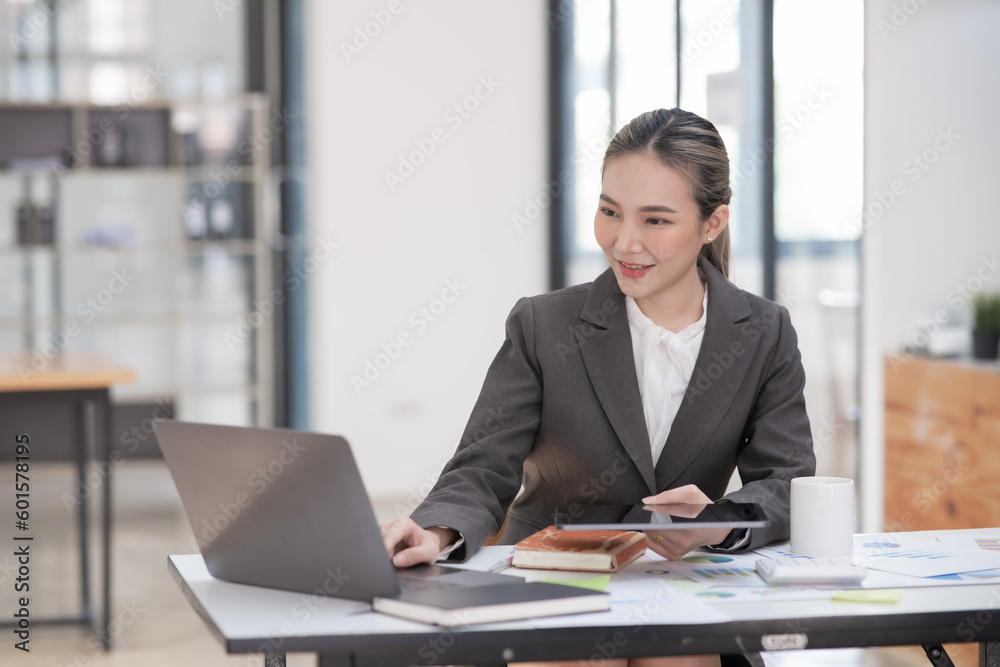 Young Asian businesswoman working on documents at office Young Asian businesswoman working on documents at office