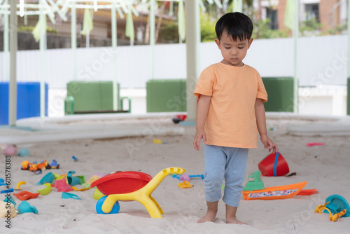 Kid Asian baby boy smile have happy fun playing toys in sandlot or sandpit or a playground or sandground photo