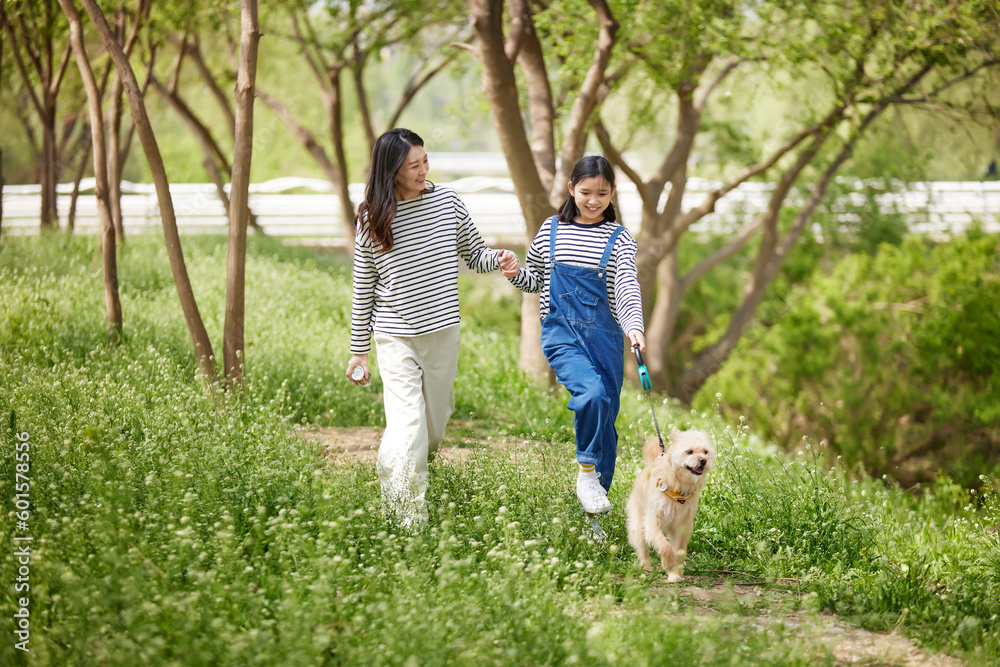 Obraz premium 강아지를 산책시키는 엄마와 딸