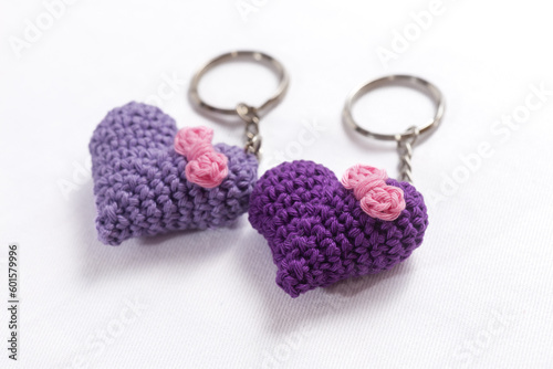 A pair of crocheted purple heart-shaped keyrings on a white background