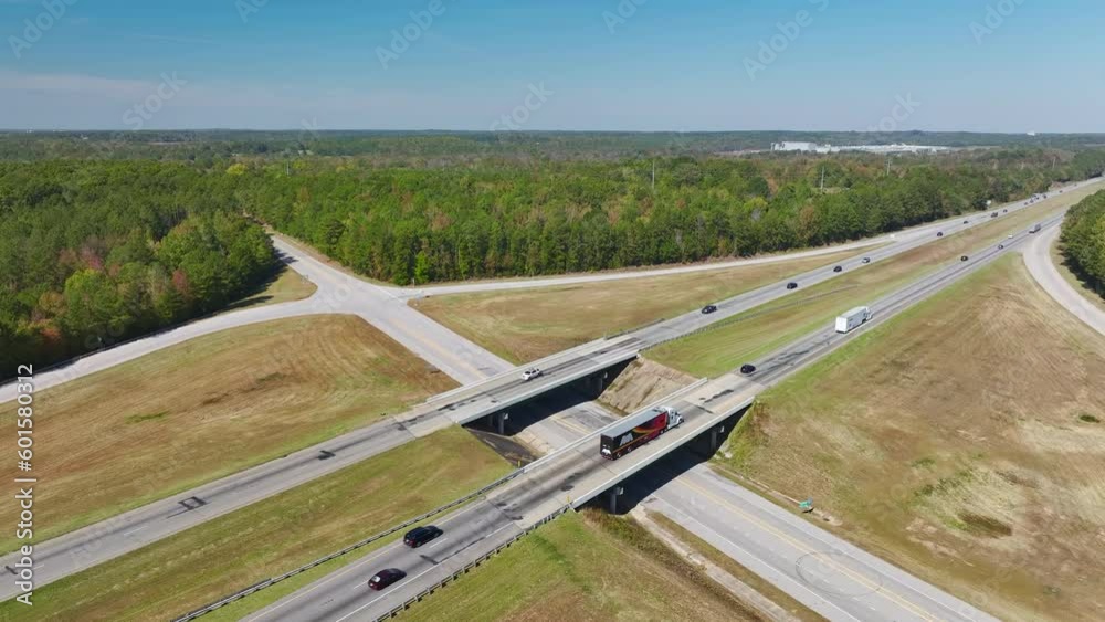 View from above of busy american highway with fast moving traffic between woods. Interstate transportation concept