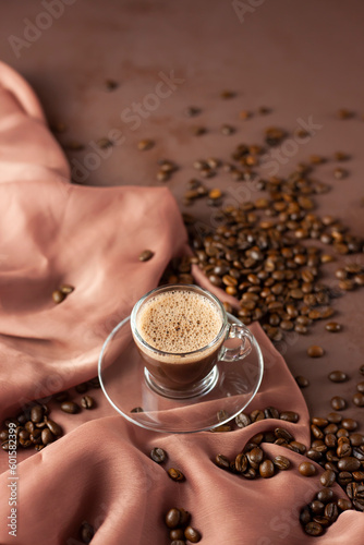 Turkish coffee in a modern glass cup. Concept scene presentation with coffee beans and same tone colors. (ID: 601582399)
