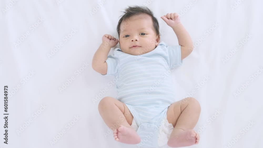 Cute little baby lying on the bed moving his arms and legs,slow motion shot. Cute little baby lying on the bed moving his arms and legs,slow motion shot.