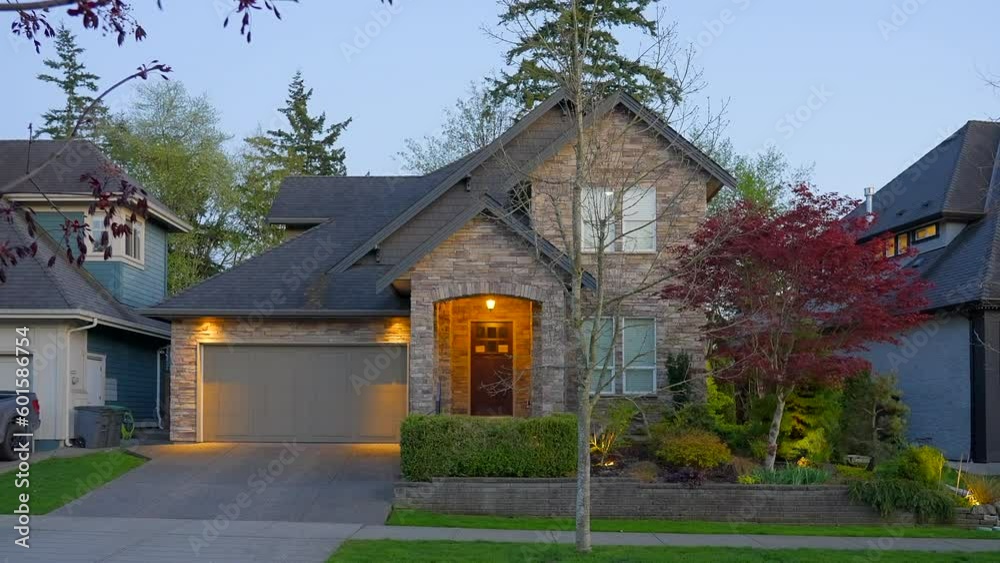 Establishing shot of two story stucco luxury house with garage door, big tree and nice landscape at night in Vancouver, Canada, North America. Night time on Apr 2023. ProRes 422 HQ. Establishing shot of two story stucco luxury house with garage door, big tree and nice landscape at night in Vancouver, Canada, North America. Night time on Apr 2023. ProRes 422 HQ.