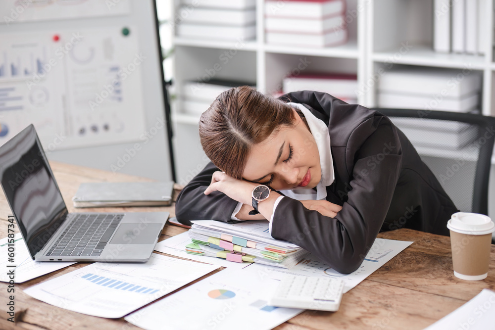 Asian businesswoman who is exhausted from work sleeping on the desk in the office. Asian businesswoman who is exhausted from work sleeping on the desk in the office.