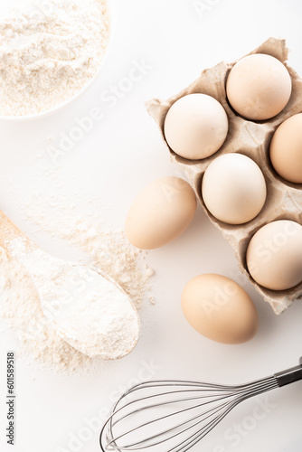 fresh chicken eggs with flour on a white background. cooking
