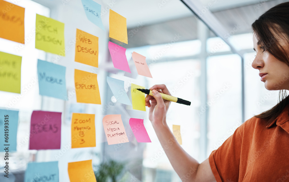Woman writing notes, brainstorming with ideas on glass board and sticky note, planning in office with focus. Creative project, agenda and female employee working, strategy and storyboard with goals - obrazy, fototapety, plakaty 