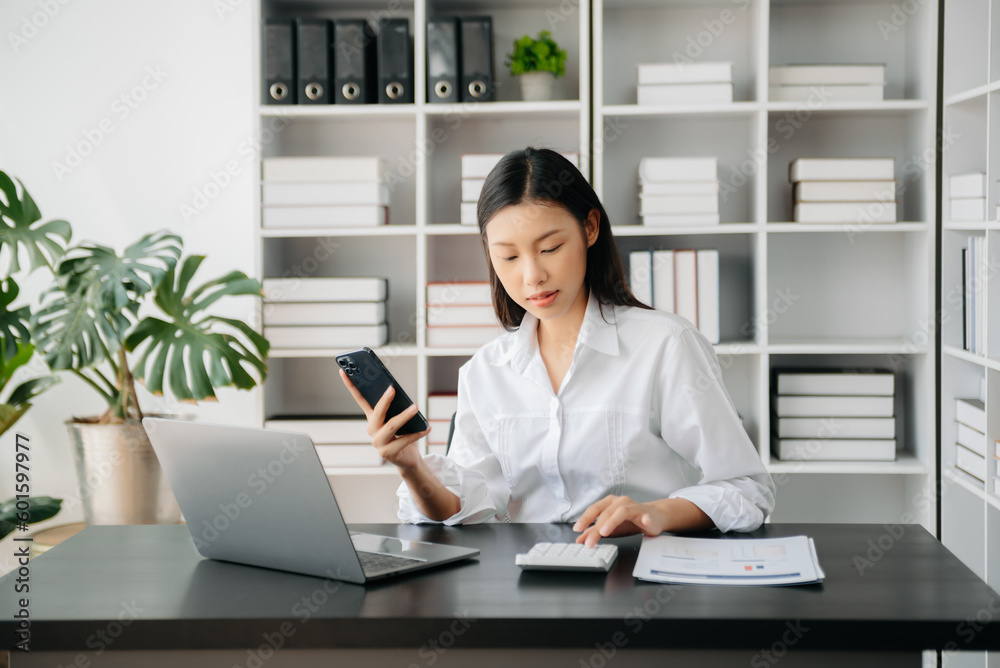 Confident Asian woman with a smile standing holding notepad and tablet at the office.. Confident Asian woman with a smile standing holding notepad and tablet at the office..