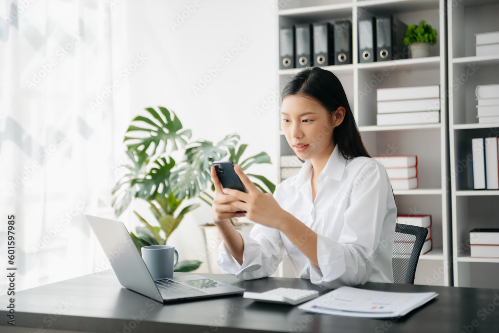 Confident Asian woman with a smile standing holding notepad and tablet at the office.. Confident Asian woman with a smile standing holding notepad and tablet at the office..