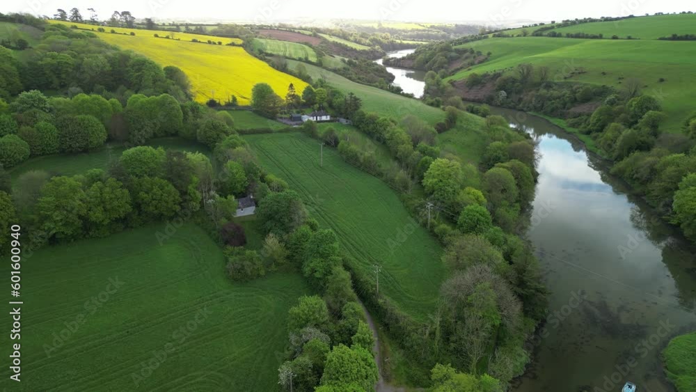 An aerial view over river and fields in Spring with yellow rapeseed filed dominating on a green hills An aerial view over river and fields in Spring with yellow rapeseed filed dominating on a green hills
