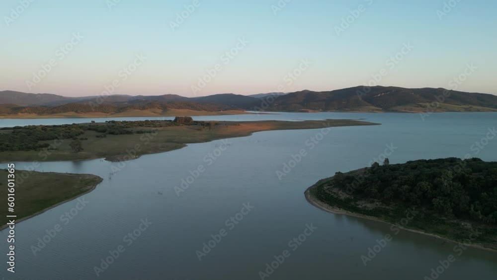 Ascend with this captivating 4K drone shot over a serene lake in Cadiz, Spain. Majestic mountains frame the panoramic view. Ideal for travel, commercials, and nature projects.