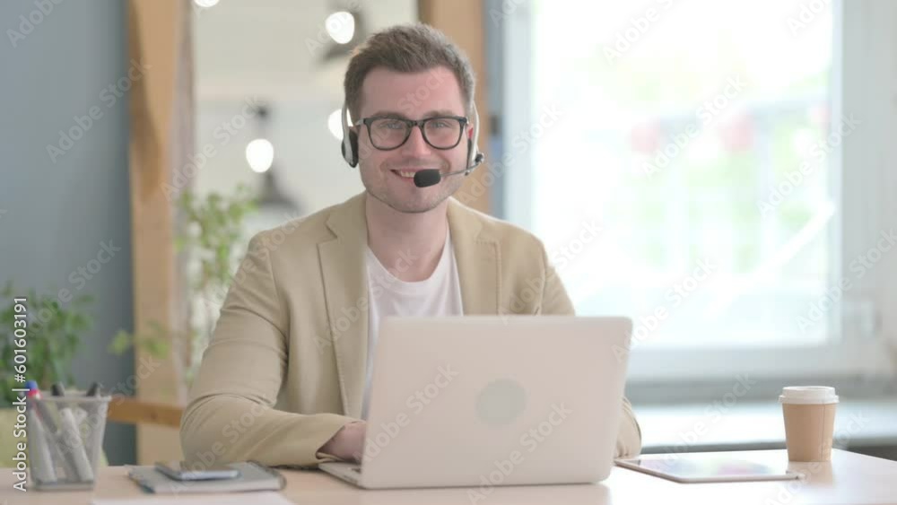 Smiling Young Businessman with Headset in Call Center Smiling Young Businessman with Headset in Call Center