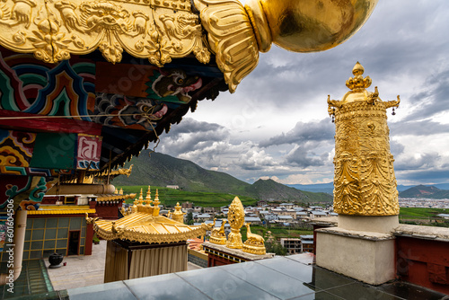 The golden praying decorations on the roof of Tibetan monastery (Shangri-La Songzanlin Monastery) at Shangri-la, Yunan, China. Dramatic sky, copy space for text