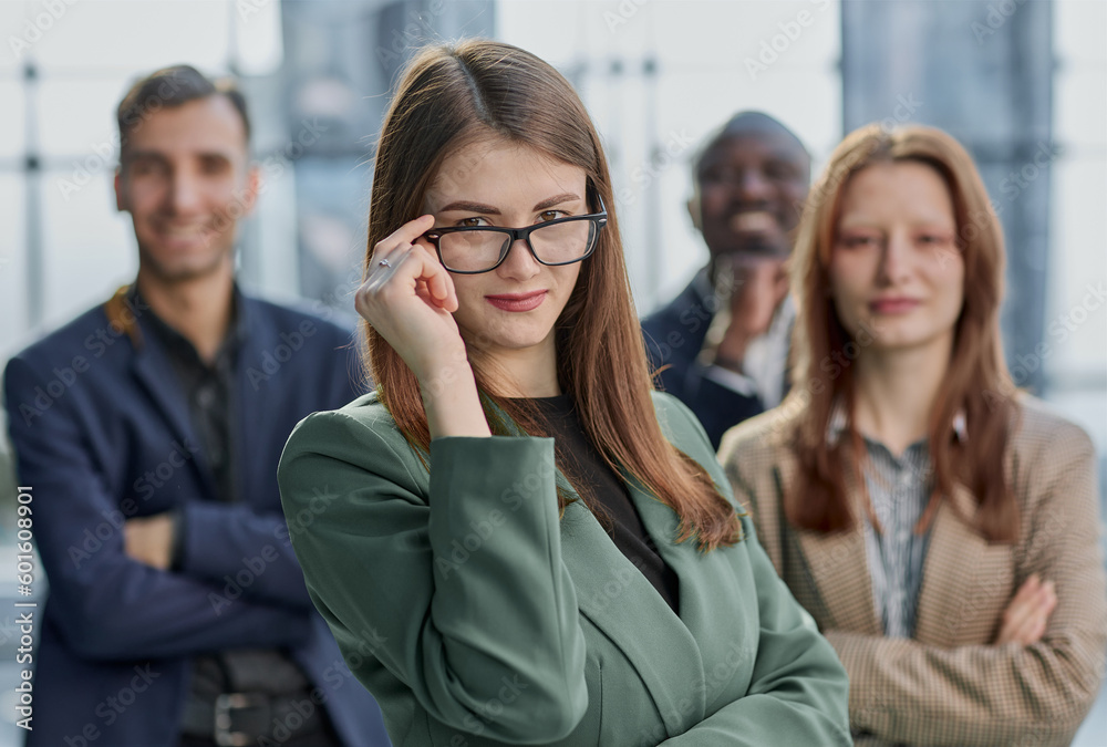 Obraz premium Portrait of a young serious business woman with colleagues