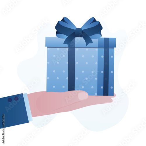 Human hand holds gift. Man gives gift box with big bow. Christmas or birthday celebration. Present package or surprise delivering. Shopping, bonus, marketing campaign. Boxing day.