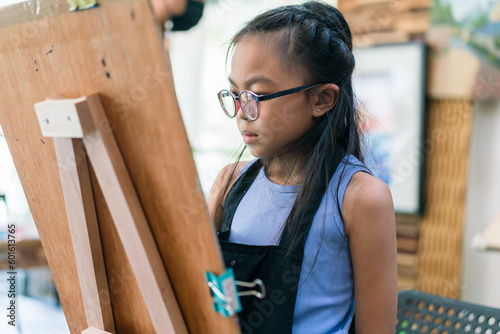 Young girl asian sitting and drawing artwork to develop abilities and improve mental health at home. Female artist drawing with inspiration.