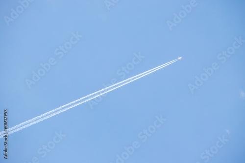 Airplane trail white against the blue sky