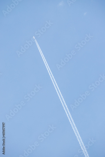 Airplane trail white against the blue sky