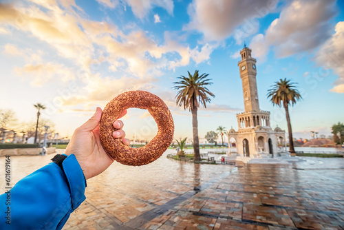 Fotobehang Hand with traditional simit turkish round bagel bread with clocktower on Konak S