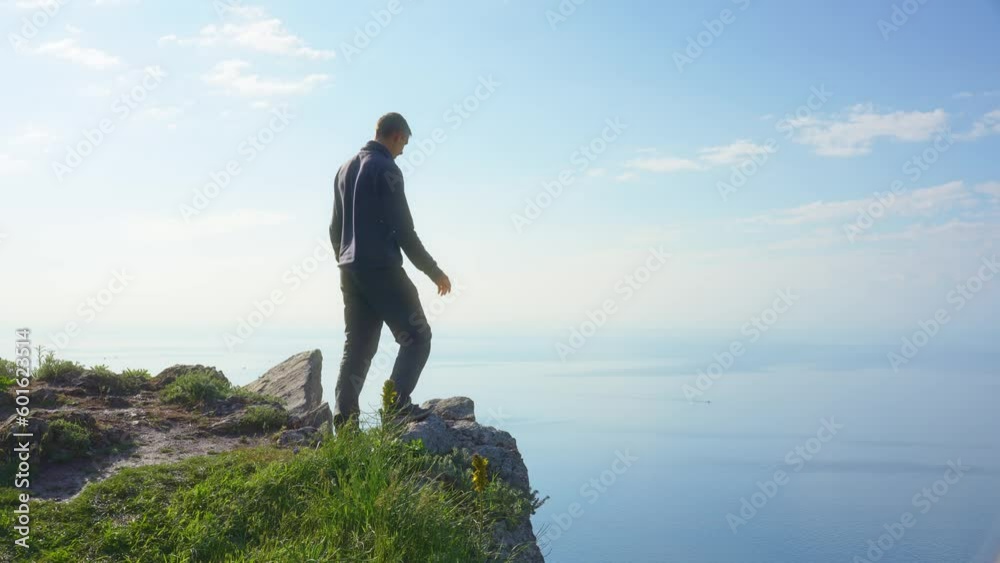 Man enoy nature and open arms on the sea cliff at day. People and nature scene. Man enoy nature and open arms on the sea cliff at day. People and nature scene.