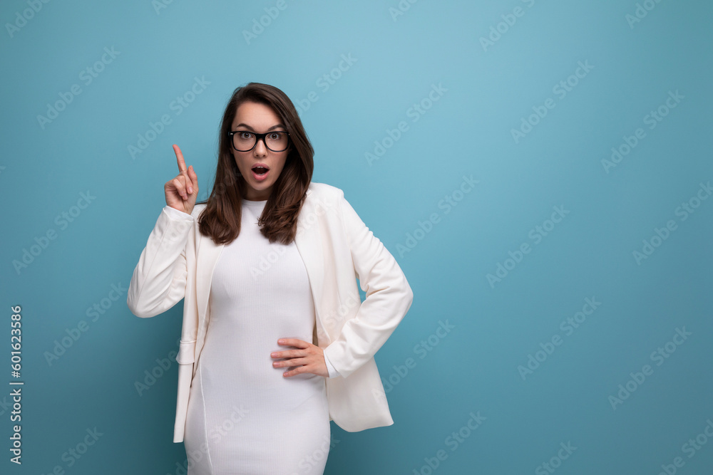 positive young business brunette woman in white office dress on blue studio background positive young business brunette woman in white office dress on blue studio background