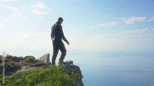 Man enoy nature and open arms on the sea cliff at day. People and nature scene. photo