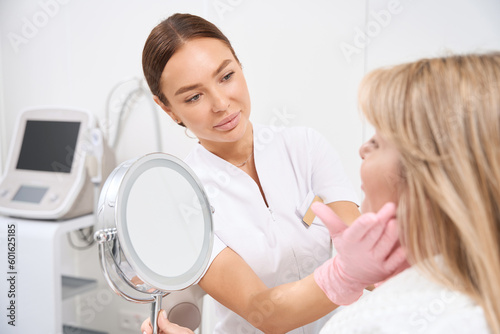 Doctor cosmetologist consults a client of an aesthetic medicine clinic