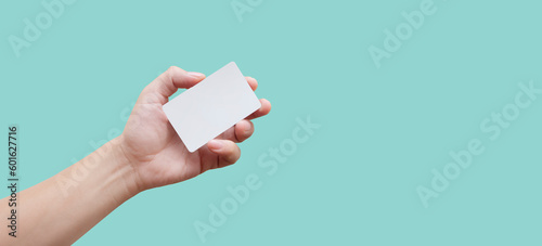 man holding a credit card / business card in his hands on a blue background