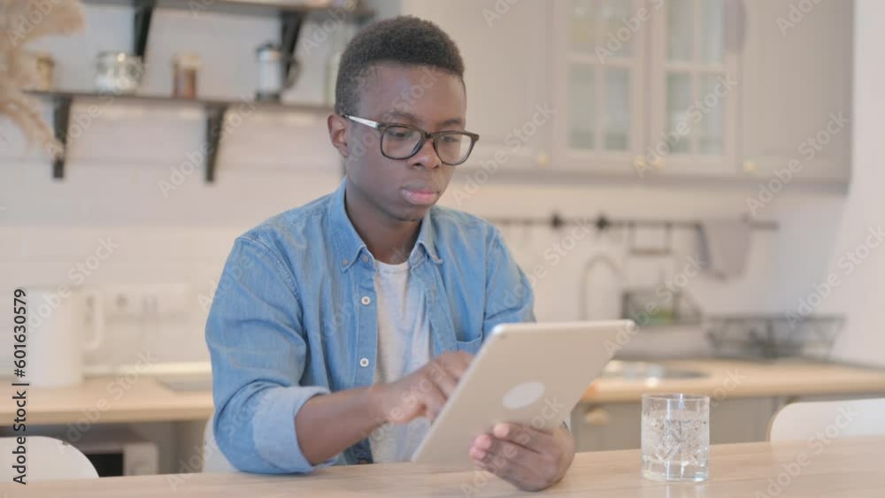 Cheerful Young African Man using Tablet PC Cheerful Young African Man using Tablet PC