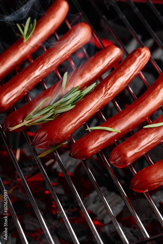 Grilled sausages with rosemary on a grill.