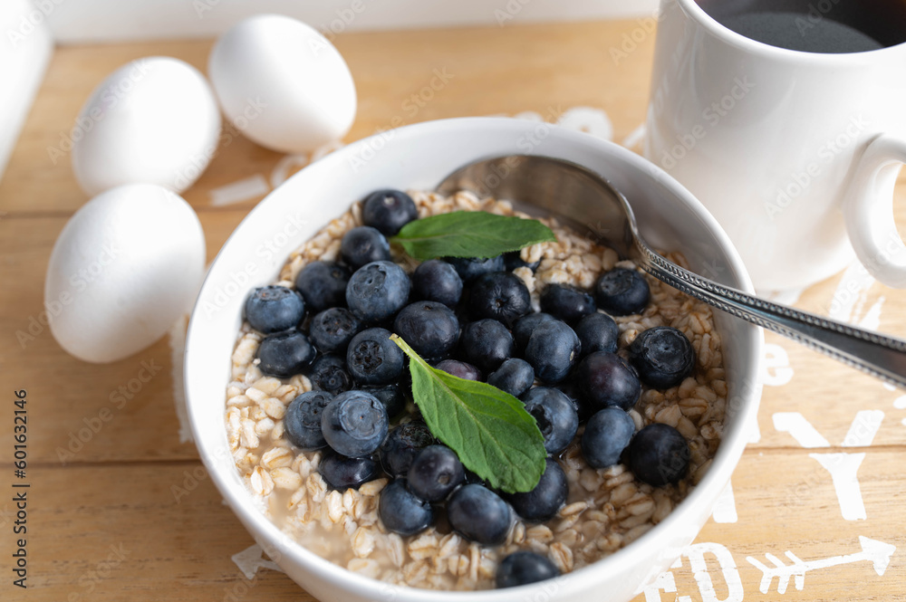 Soaked oats in water with fresh blueberries in a bowl for breakfast Soaked oats in water with fresh blueberries in a bowl for breakfast