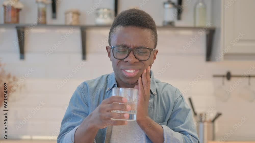 Young African Man Having Toothache while Drinking Water Young African Man Having Toothache while Drinking Water